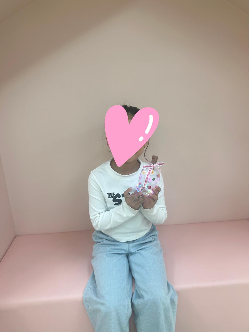 여자 아이가 봄보틀 무드등을 완성하여 의자에 앉아 있는 모습입니다.